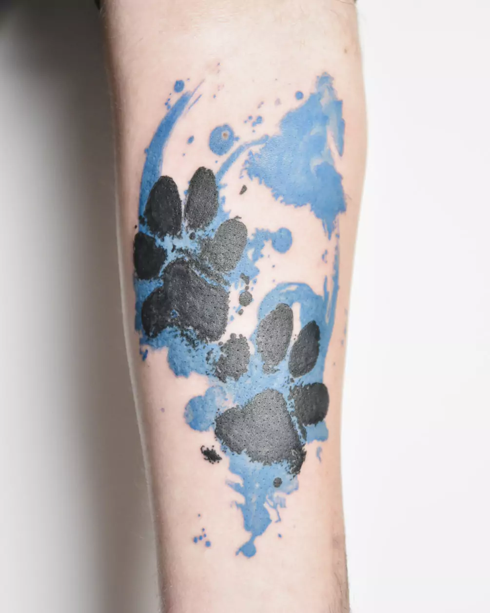 paw print tattoo on blue abstract